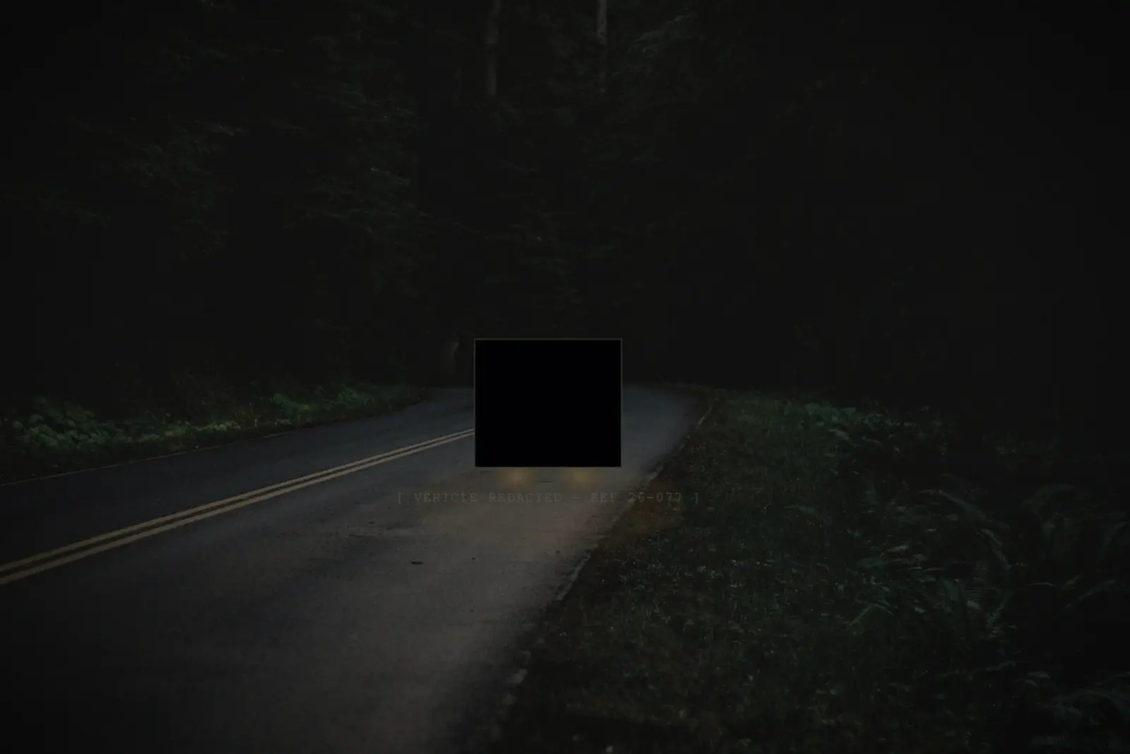 Night photograph of Fire Road 12 — the staged vehicle redacted by Bureau counsel, headlight glow still visible beneath the box